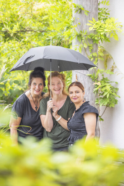 Drei Frauen unter einem Regenschirm